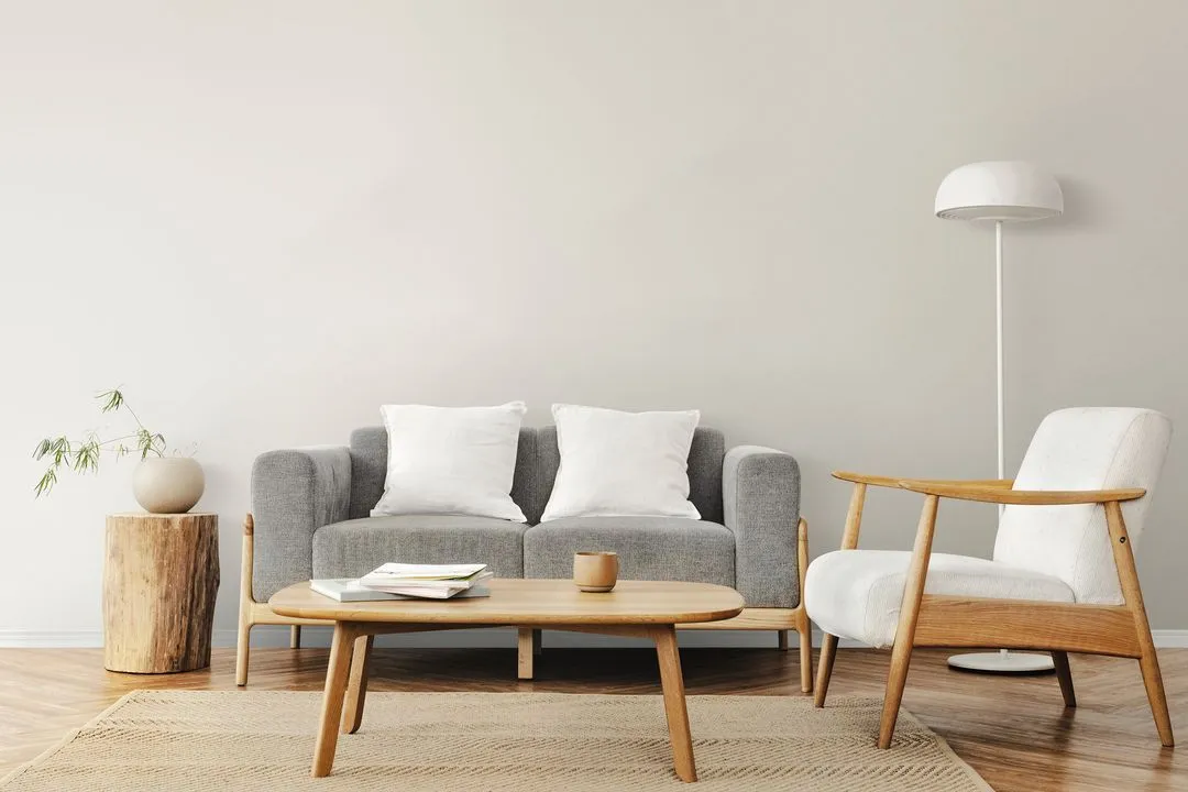 Sala de estar de estilo escandinavo com sofá cinza, poltrona branca e mesa de centro de madeira